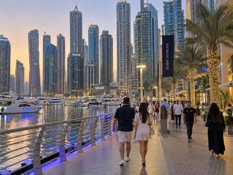 Waterfront promenade lined with palm trees and skyscrapers at golden hour