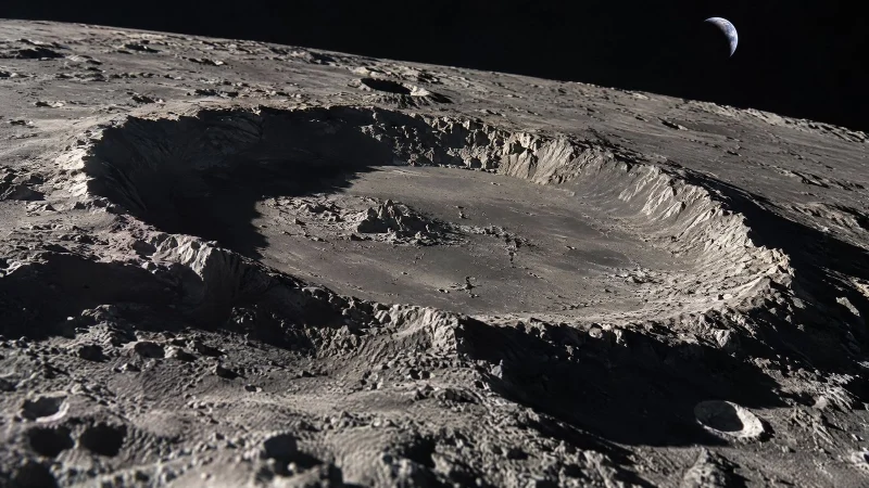 Lunar surface with a large impact crater, low sunlight casting long shadows across its rim