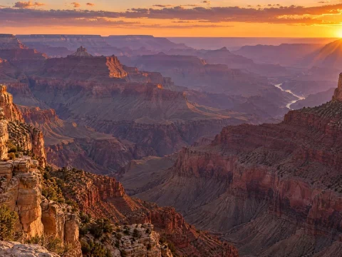 Huge canyon glowing at sunset with a river winding far below