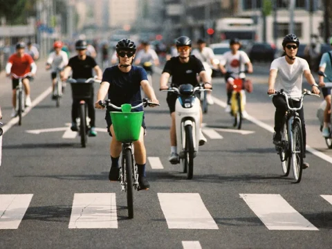 Cyclists and electric scooter riders in a busy protected bike lane at rush hour