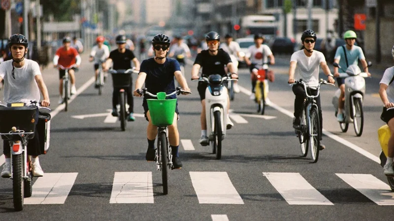 Cyclists and electric scooter riders in a busy protected bike lane at rush hour