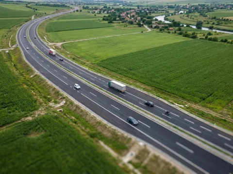 Aerial view of a reopened highway bypass with light traffic in both directions between green fields